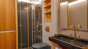 Un baño moderno con ducha, inodoro, lavabo y tocador.