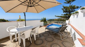 A terrace with a table and chairs, a sun lounger, and a pool. - AP433 VILLA LA NORIA (Nerja)