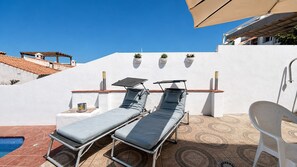A rooftop terrace with two sun loungers, a small pool, and a white wall with potted plants. - AP433 VILLA LA NORIA (Nerja)
