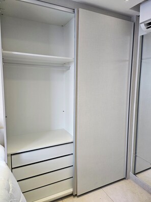 Un closet amplio con puerta corrediza, barra metálica y repisa.