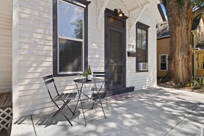 A house with a porch, a table with chairs, and a bottle of wine. - Akin East Pet-friendly Furnished Monthly Rental (Fort Collins)