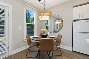 A modern kitchen with a dining table, chairs, and a refrigerator. - Akin East Pet-friendly Furnished Monthly Rental (Fort Collins)