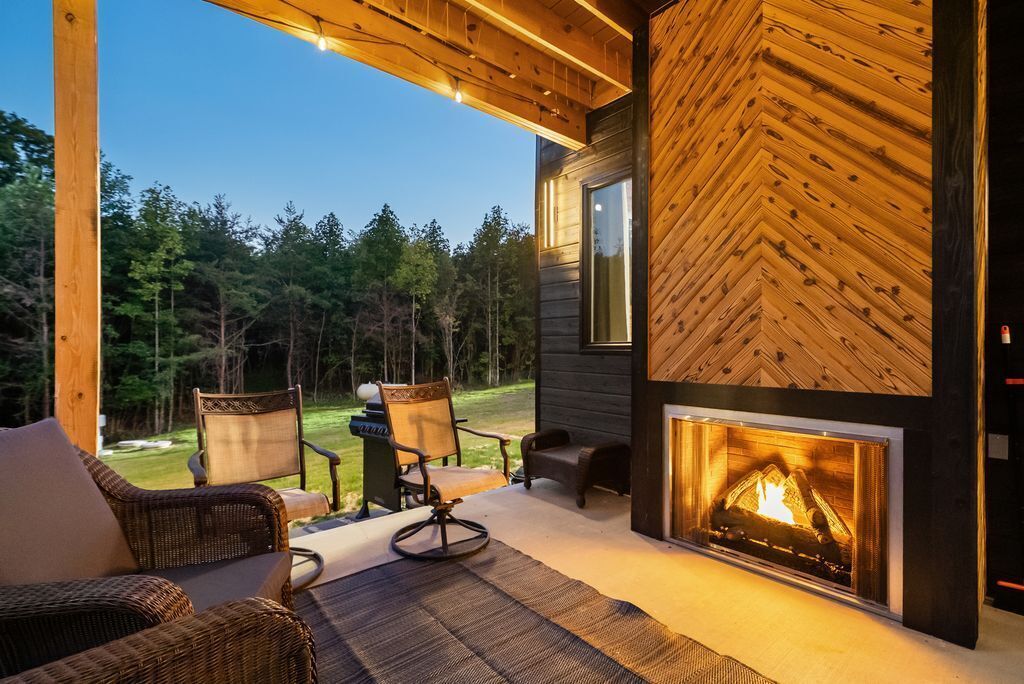 A cozy outdoor seating area with wicker furniture and a fireplace.