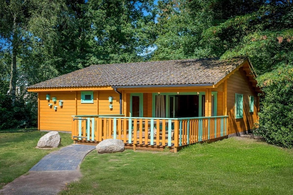 Una baita di legno con un portico e un sentiero che vi conduce.