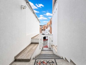 A narrow alleyway with a wooden staircase leading to a building entrance. - Ocean Dream House (Costa Adeje)