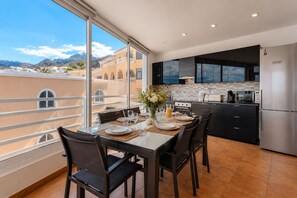 A modern kitchen with a dining area, large windows, and a view of the mountains. - Ocean Dream House (Costa Adeje)