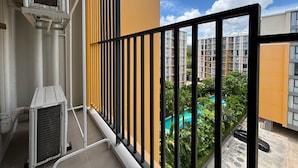 Un balcó amb vista a una zona residencial, incloent una piscina i edificis alts.