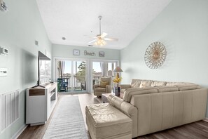 A spacious living room with a beige sectional sofa, a ceiling fan, and a view to the outside. - 10% off 3-7 nights thru Dec. 2BR 2BA condo. Lake view, gated comm. Short walk to beach. (North Myrtle Beach)