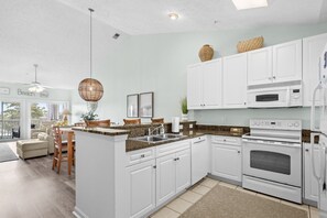 A modern kitchen with white cabinetry, a granite countertop, and stainless steel appliances. - 10% off 3-7 nights thru Dec. 2BR 2BA condo. Lake view, gated comm. Short walk to beach. (North Myrtle Beach)