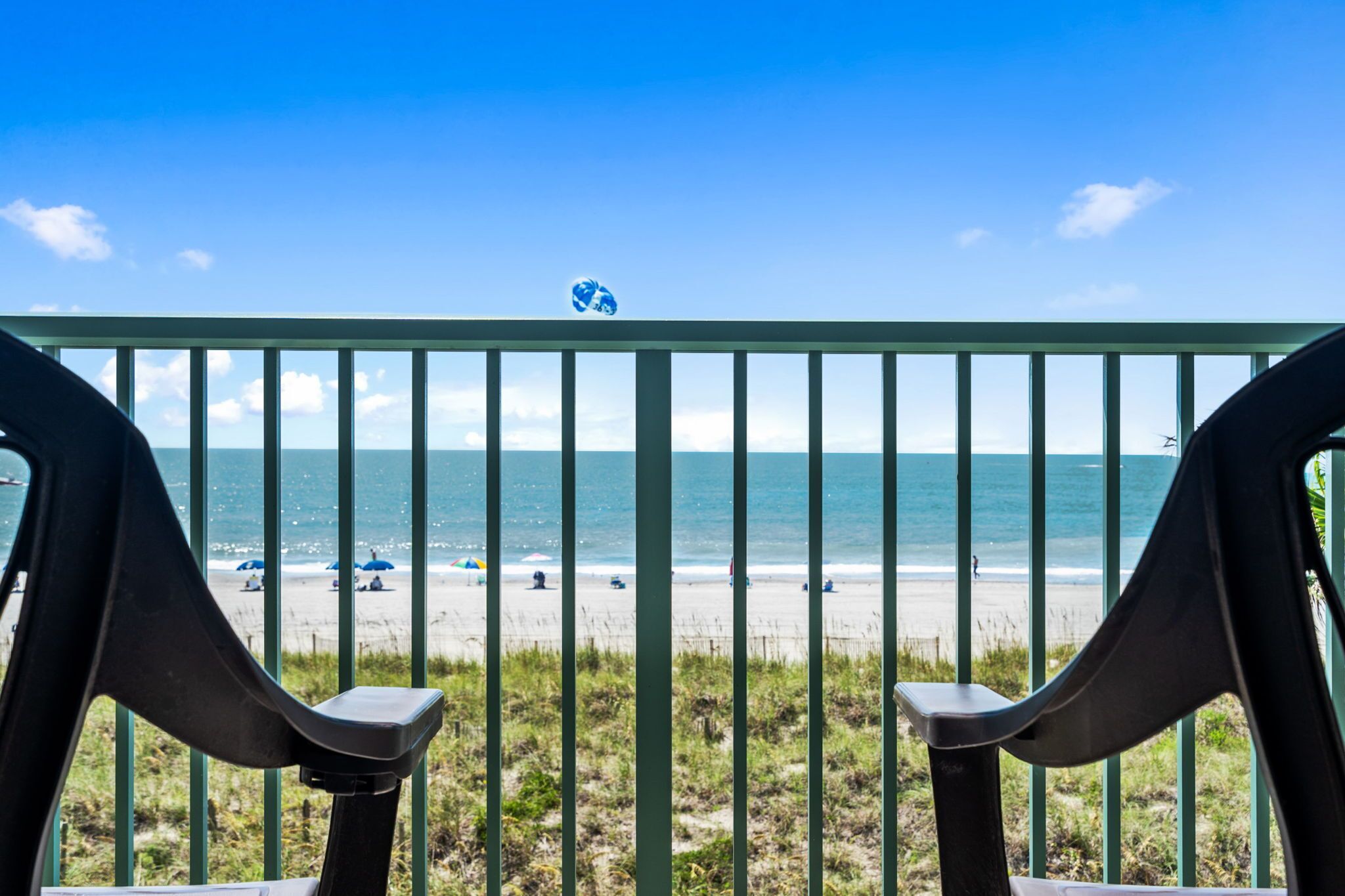Ein Balkon mit Blick auf einen Strand und den Ozean.