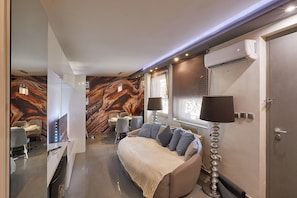 A modern bedroom with a marble-patterned wall, a bed with a beige blanket, and a bedside lamp. - Designer 2BD, City Center, Own Terrace, Own Entrance (Sofia)