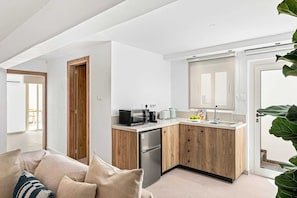 A compact kitchen with a refrigerator, microwave, toaster, and sink. - Aurelia Beach Residence by Nomads (Paphos)