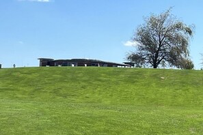 A building on a grassy hill with a clear sky. - Holiday home with 2 bedrooms (Litzelsdorf)