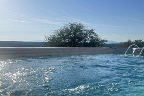 A swimming pool with a clear view of the sky and a tree in the background. - Holiday home with 2 bedrooms (Litzelsdorf)