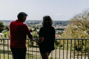 Two people standing on a balcony with a view of a landscape. - Holiday home with 2 bedrooms (Litzelsdorf)