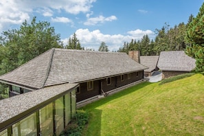 A modern house with a sloped roof, a glass conservatory, and a well-maintained lawn. - Holiday home in Anger with swimming pool (Anger)