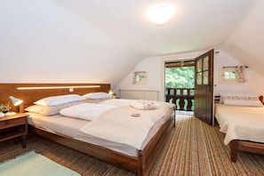 A bedroom with a large bed, a bedside table, a nightstand, and a window with a view of greenery. - Holiday home in Anger with swimming pool (Anger)