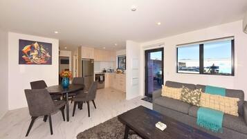 A modern living room with a sofa, coffee table, and dining area.