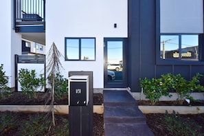 A modern building with a black mailbox marked '1/31' and a visible entrance. - The Modern Hideaway for Every Stay (Christchurch)
