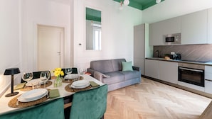 Cozinha moderna com micro-ondas, forno e área de refeições com mesa posta para dois.