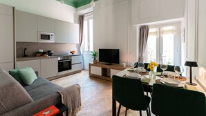 Cozinha moderna com micro-ondas, forno e área de jantar com mesa posta para dois.