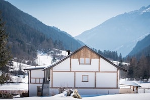 Un edificio de estilo chalet con techo inclinado, revestimiento de madera y un pequeño porche.