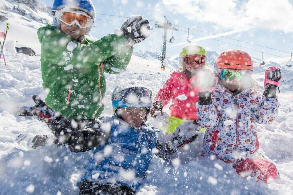 Un gruppo di persone con abbigliamento invernale su un pendio innevato.