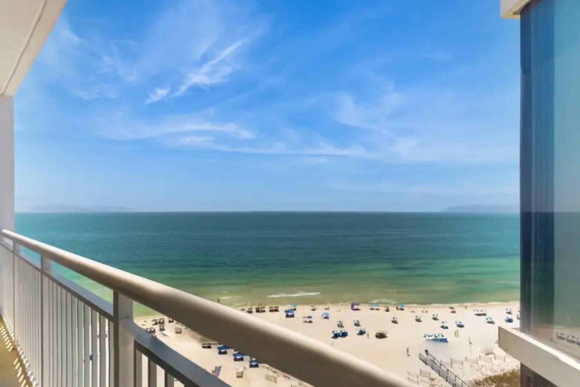 A balcony with a view of a beach and ocean.