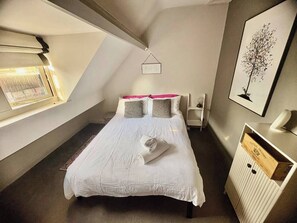 A bedroom with a bed, a window, a radiator, and a framed picture on the wall. - Gracious Apartment in Historic Sheffield Georgian Quarter (Sheffield City Centre)