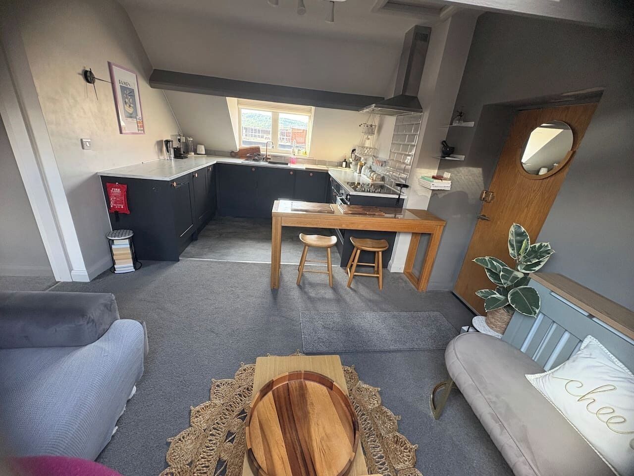 A modern kitchen with a dining area, a sofa, and a small table with a placemat.