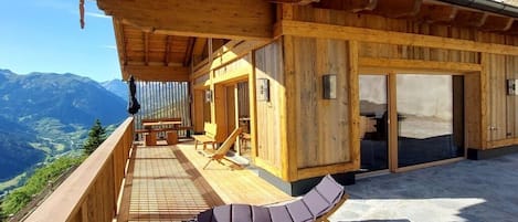 Una cabaña de madera con balcón que da a un paisaje montañoso.