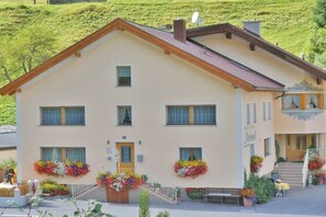 A two-story building with a sloped roof, multiple windows, and a front entrance with a staircase. - Holiday apartment in Kappl with swimming pool (Kappl)