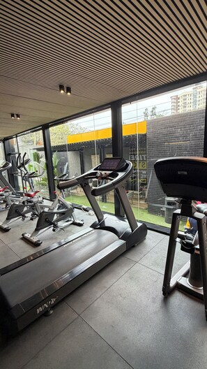 Un gimnasio con cintas de correr, bicicletas estáticas y equipo de ejercicio.