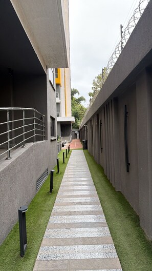 Un sendero estrecho bordeado por edificios de diseño moderno, que conduce a la entrada de un edificio.