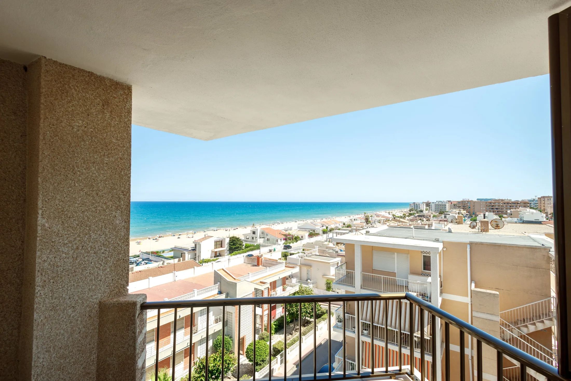 Un balcon avec vue sur une plage et sur le paysage urbain.