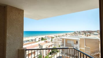 Un balcon avec vue sur une plage et sur le paysage urbain.