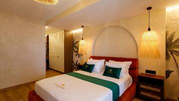 Una habitación de hotel con cama, mesita de noche, armario y un amplio ventanal.