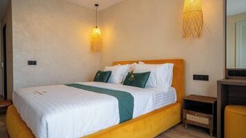 A hotel room with a bed, bedside tables, and a mirror.