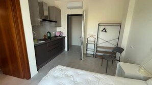 Un dormitorio pequeño con cama, escritorio, silla y armario.