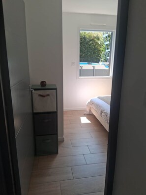 Une chambre à coucher avec un lit, une fenêtre et un plancher en bois.