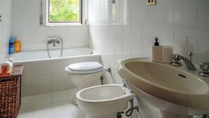 Un baño con bañera, inodoro y lavamanos.