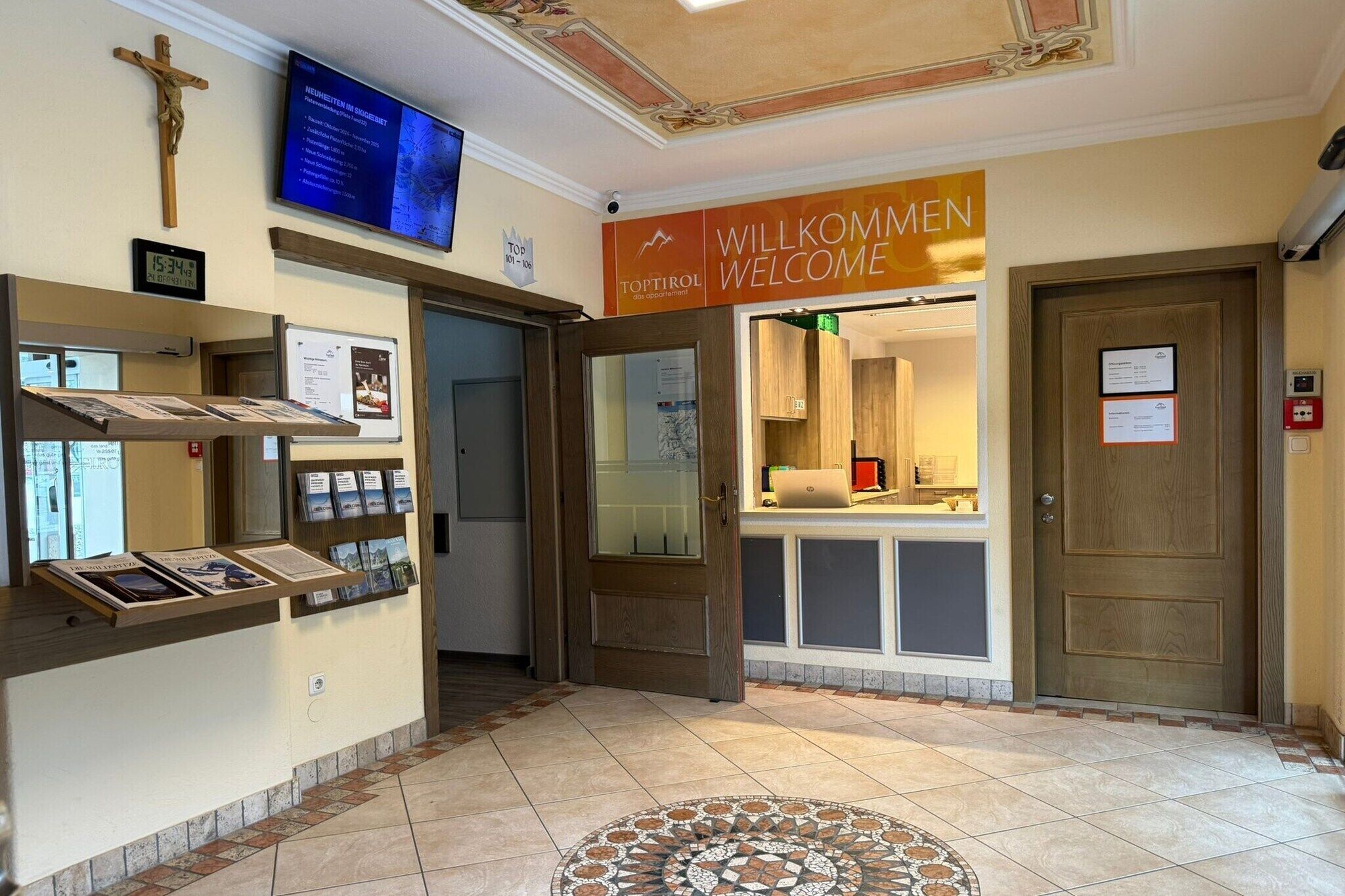 A reception area with a welcome sign, a cross, and a digital display.