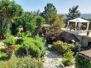 A garden with a stone pathway, a gazebo, and a view of the sea. - Oleander Stone House.
Far from the madding crowd surrounded by nature. (Lemona)