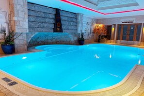 An indoor swimming pool with a stone wall and a sign reading 'TEPIDARIUM'. - Holiday apartment with wellness area (Längenfeld)