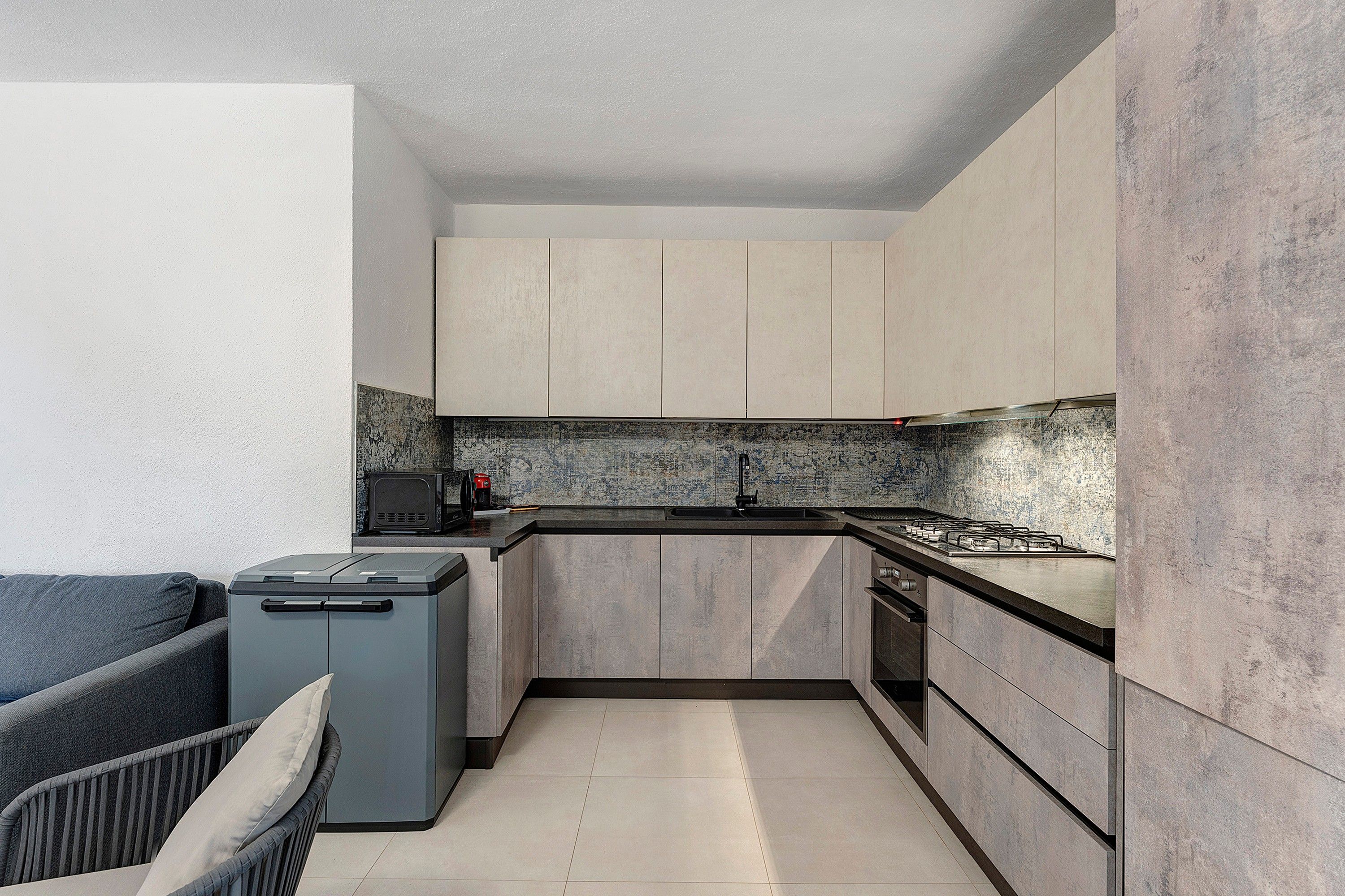 Una cocina compacta con estufa integrada, microondas y cafetera.