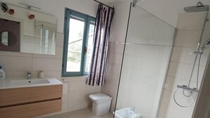 A modern bathroom with a glass shower enclosure, a toilet, and a sink with a mirror. - Villa 'Casa Bougainvillea' with Mountain View, Wi-Fi and Air Conditioning (Lu Muntiggiu di La Petra I)