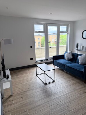 Een moderne woonkamer met een bank, een salontafel en een tv-meubel.