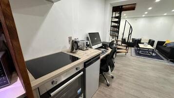 Et moderne køkken med indbygget komfur, opvaskemaskine og en bærbar computer på bordpladen.