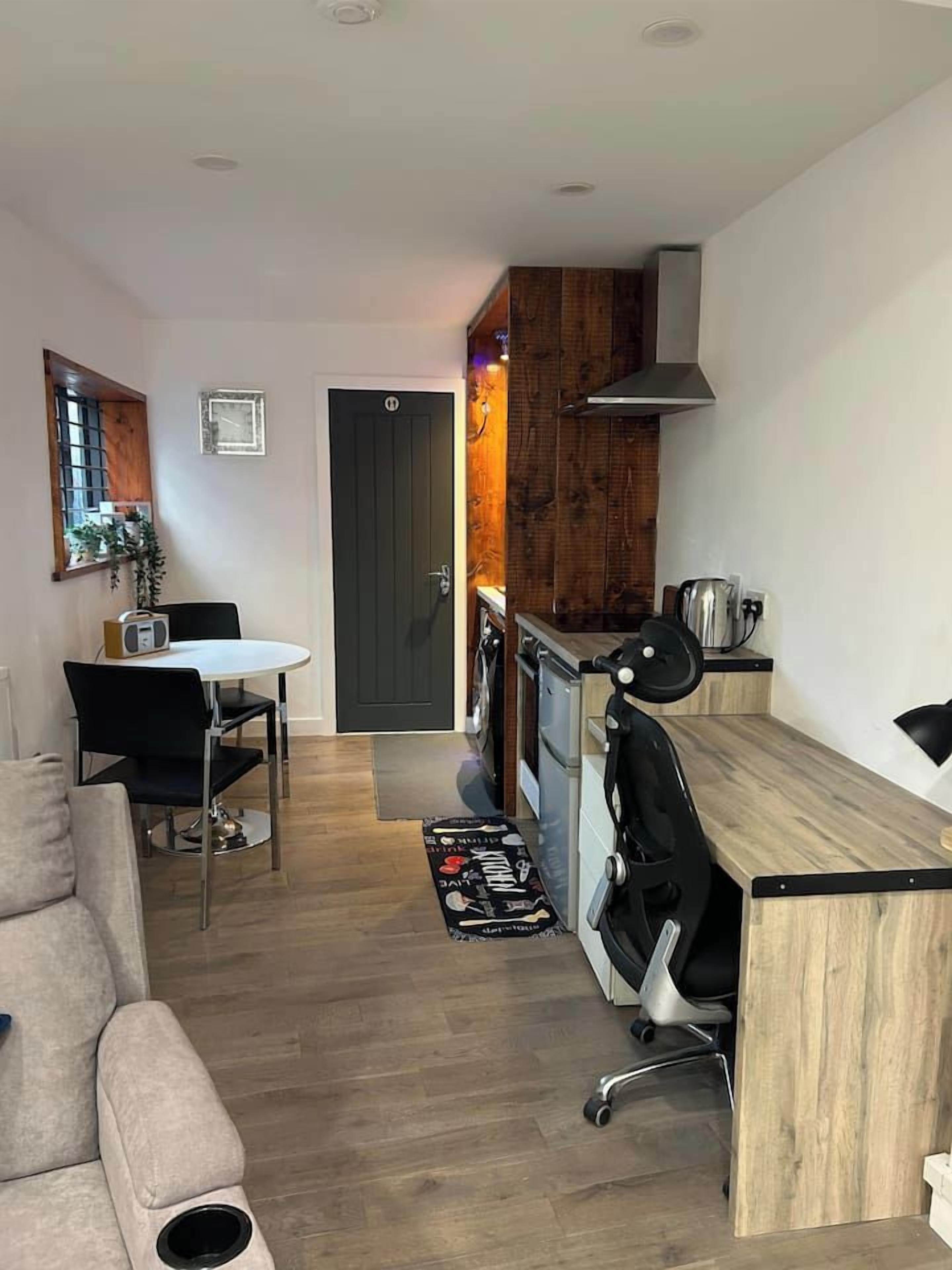 A compact living space with a kitchenette, a dining area, and a seating area.