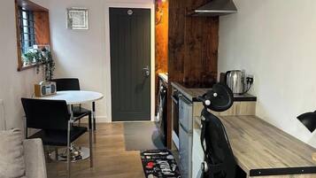 A compact living space with a kitchenette, a dining area, and a seating area.
